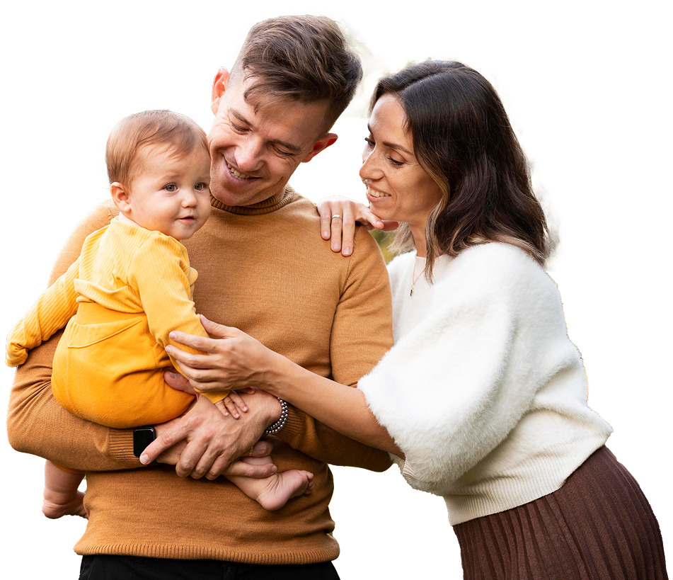 Parents smiling while holding a baby dressed in yellow, standing together at Mambourin Doctors.